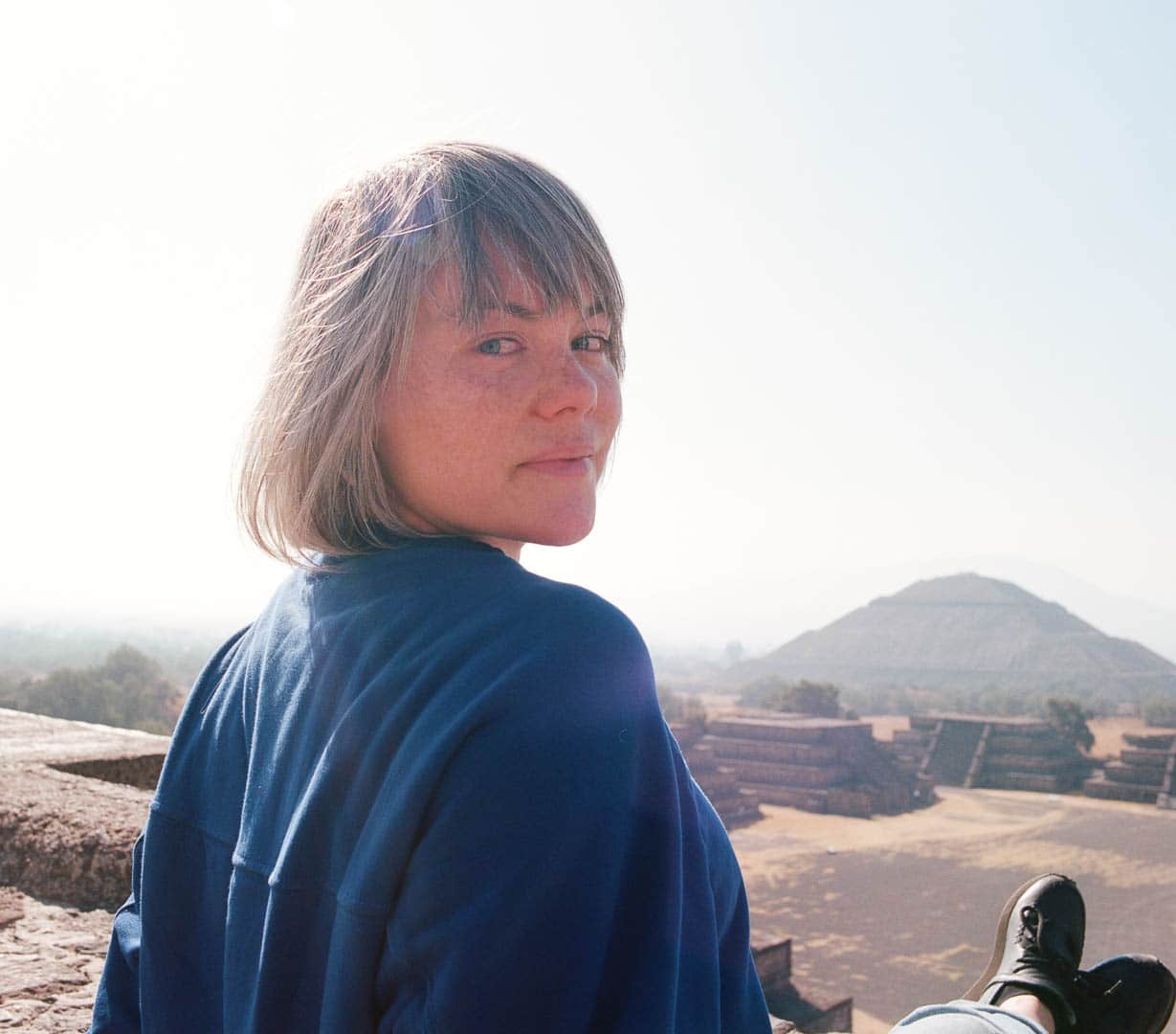 A close up of a woman atop a Teotihuacan pyramid