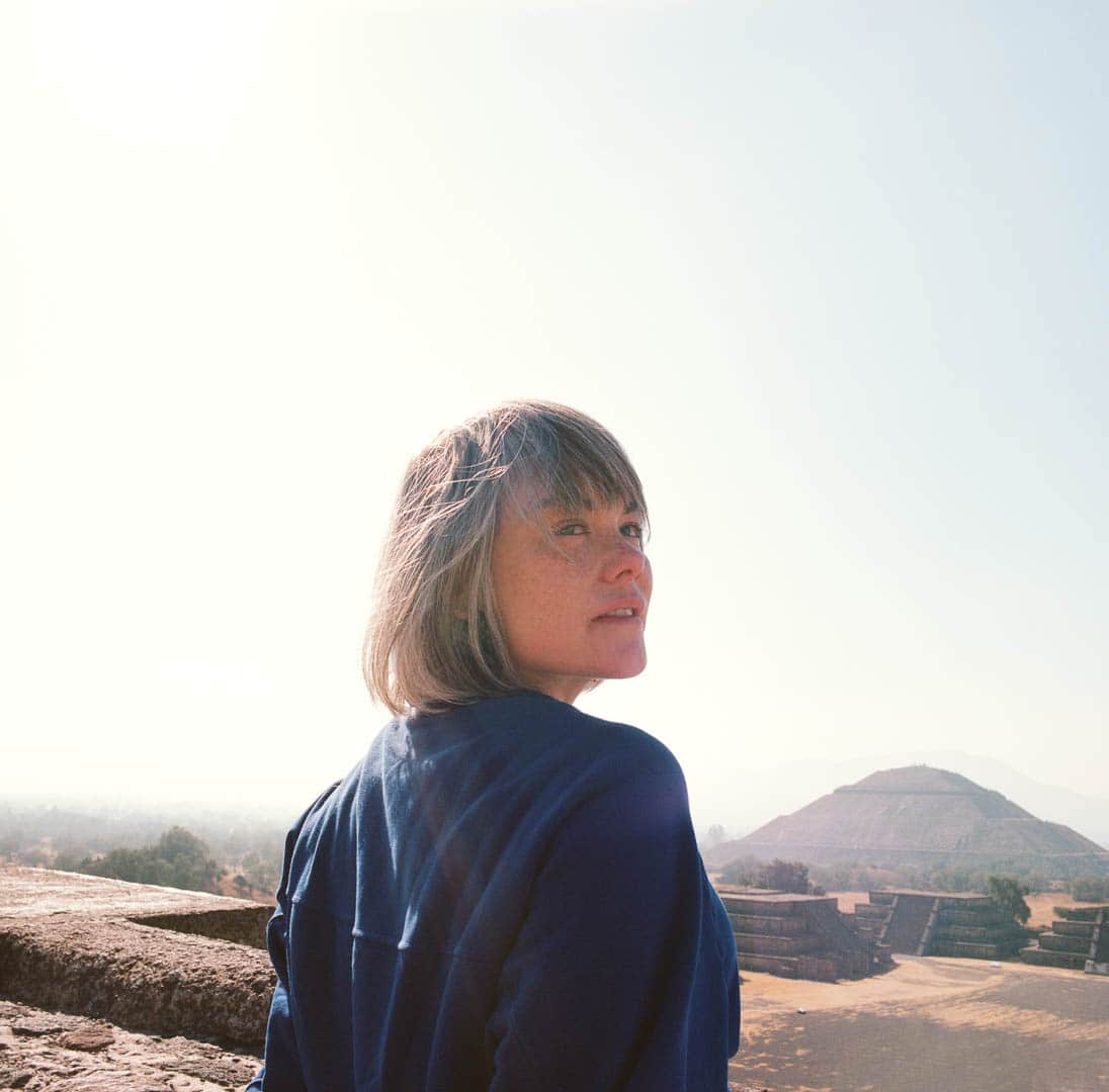 A close up of a woman atop a Teotihuacan pyramid