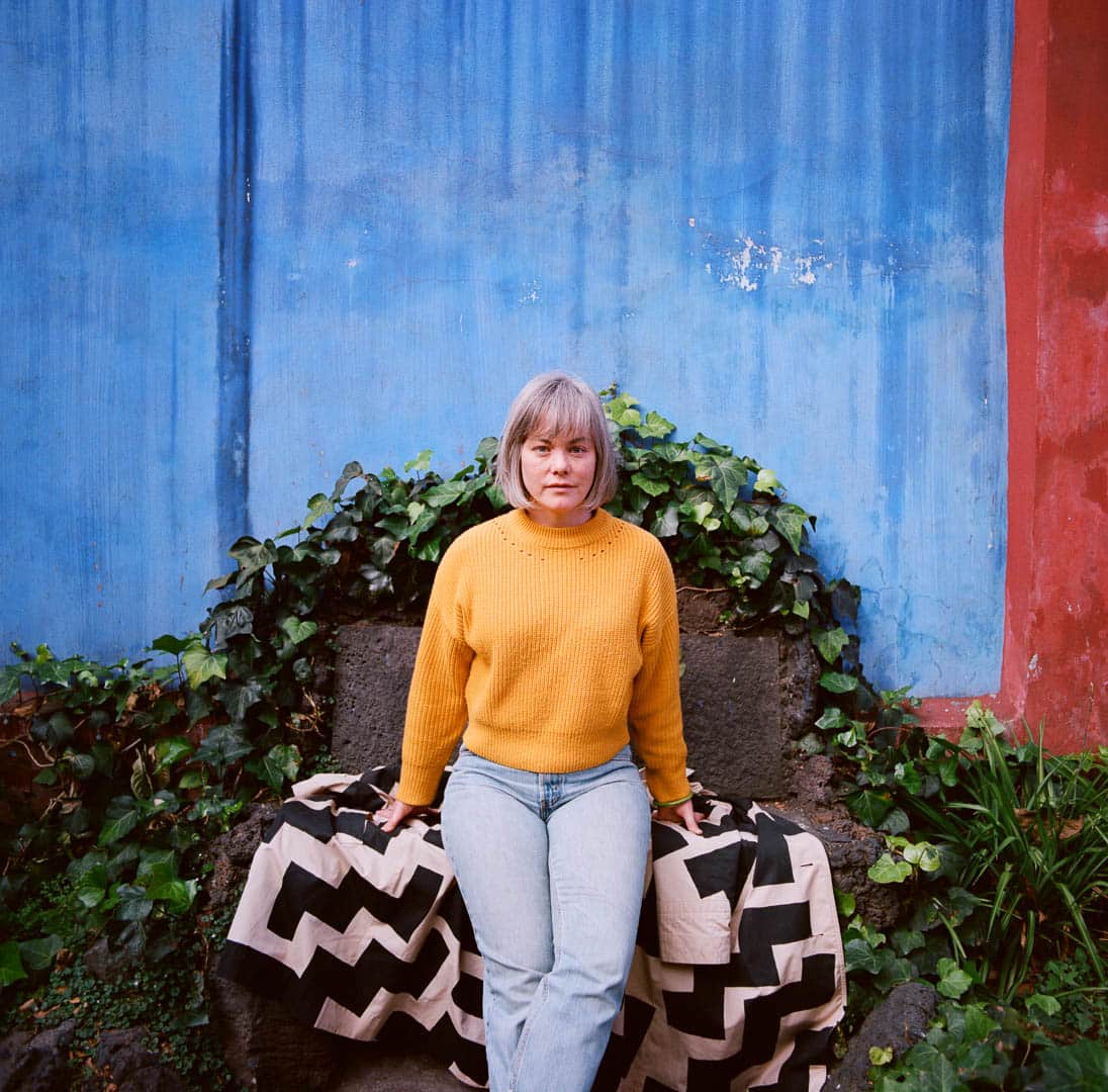 A woman posing against a wall at Frida Kahlo’s home