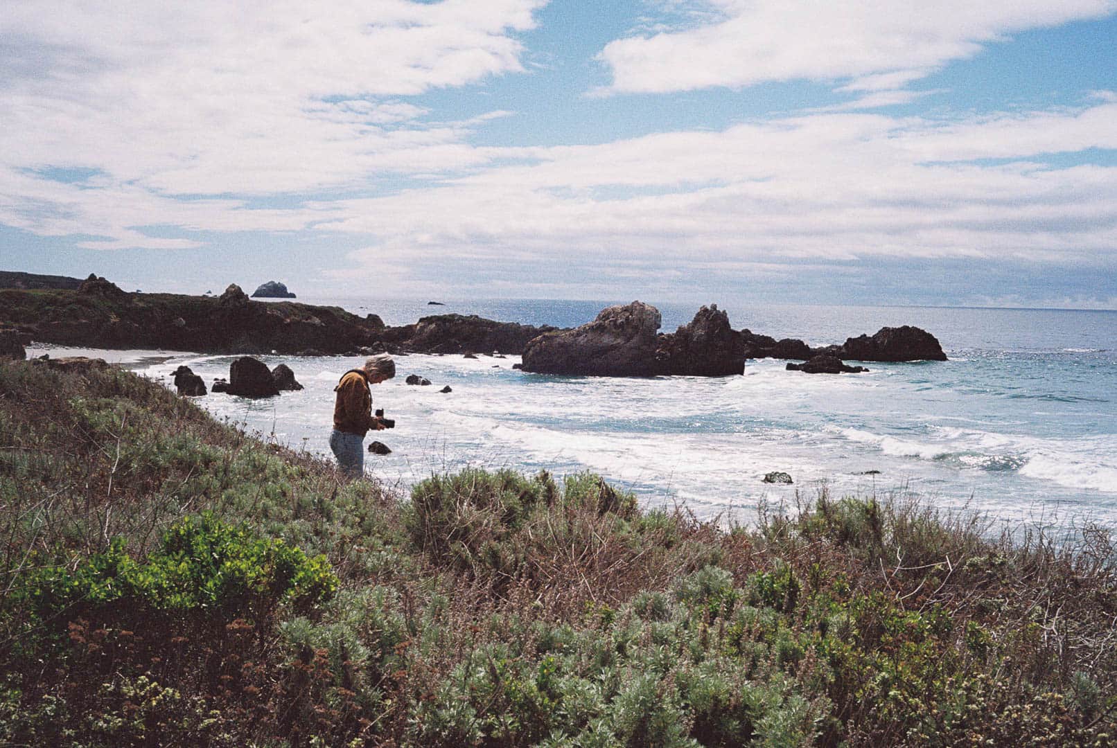 A woman taking a photograph off the bluffs