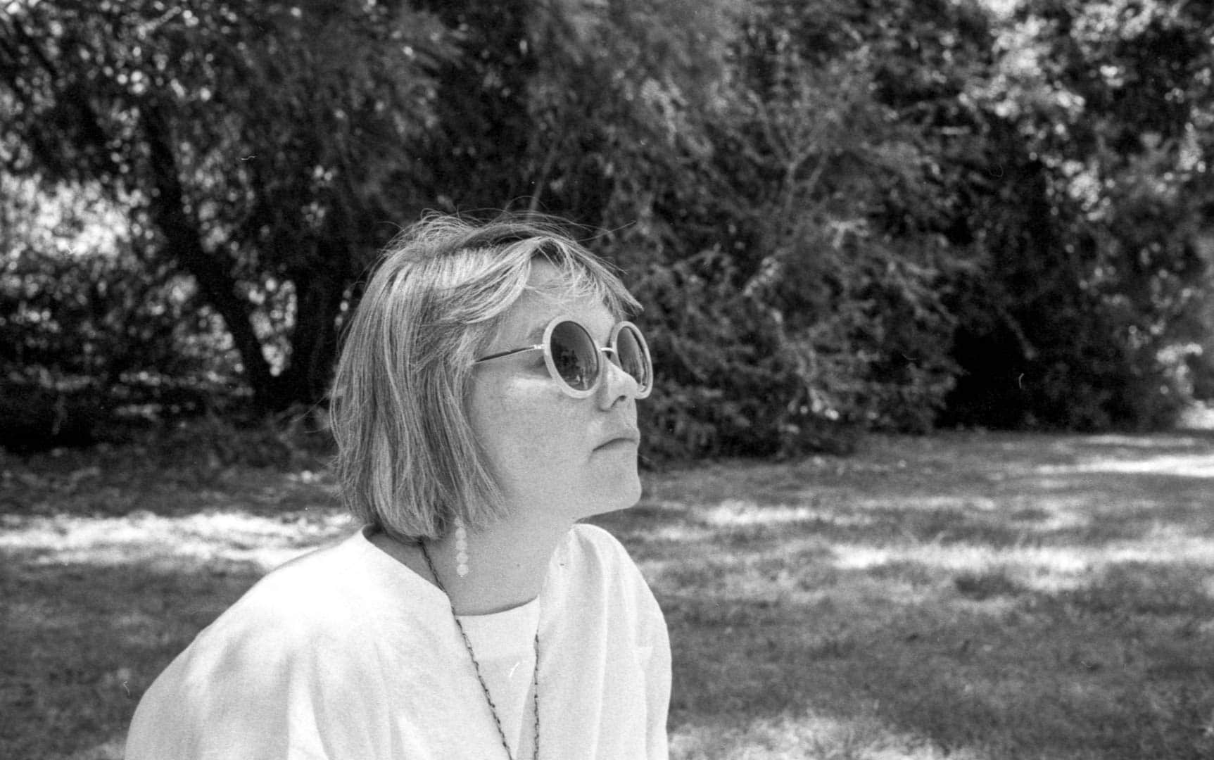 My wife wearing round sunglasses in the park