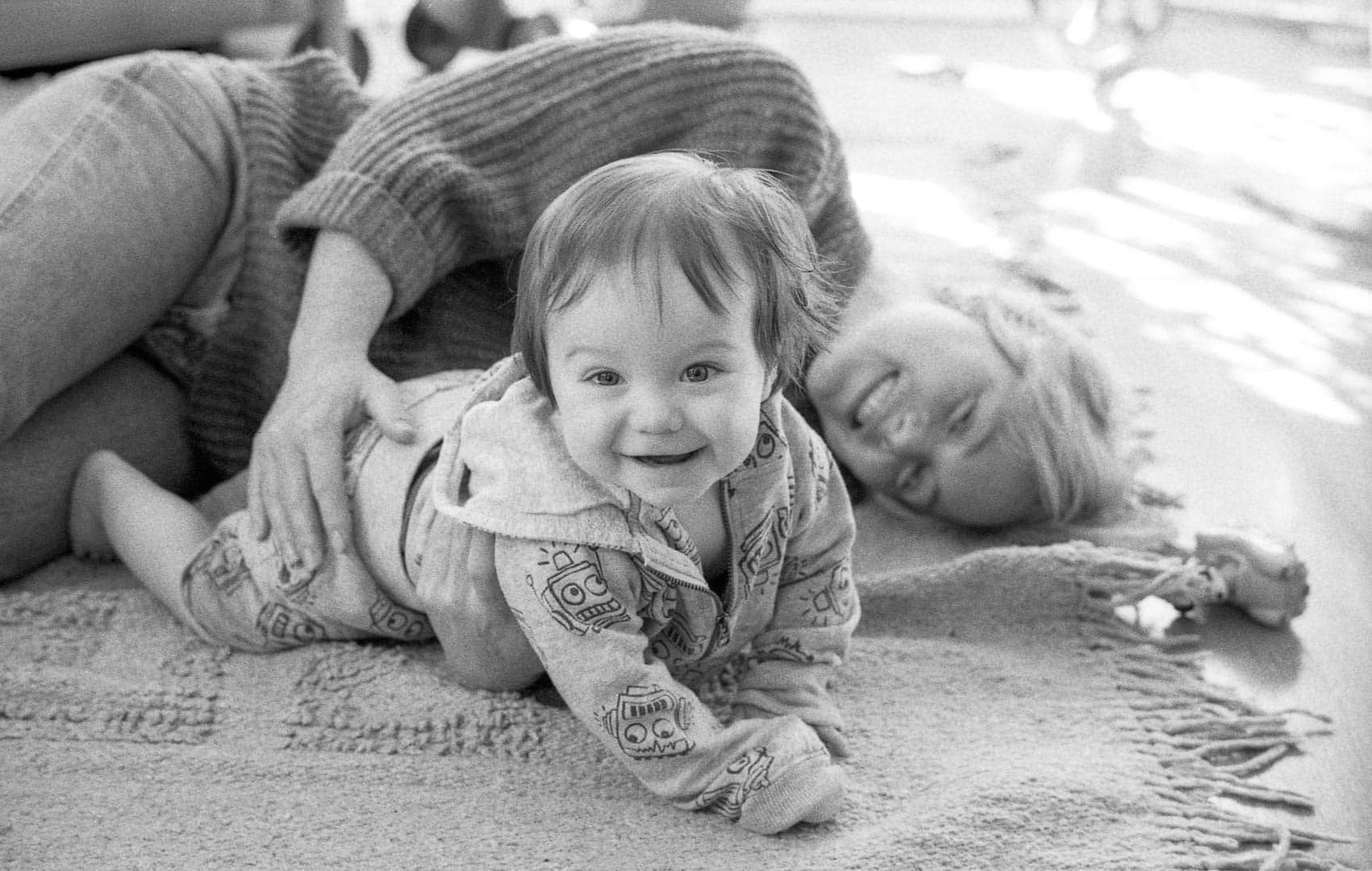 A woman and child playing on a living room floor