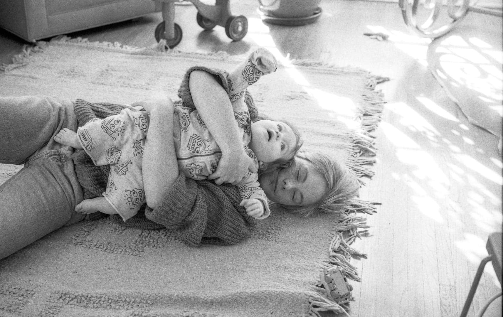 A woman and child playing on a living room floor