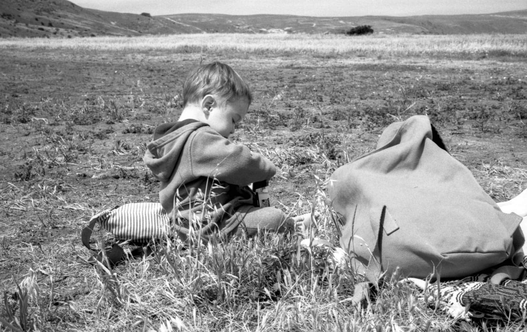 A baby playing in a field