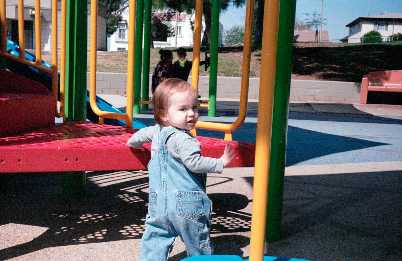 A young toddler looking back while playing on the playground