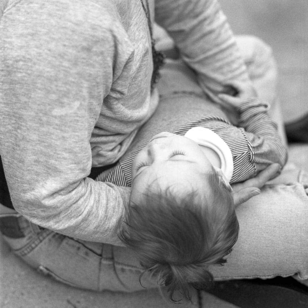 A baby asleep on his mother’s lap