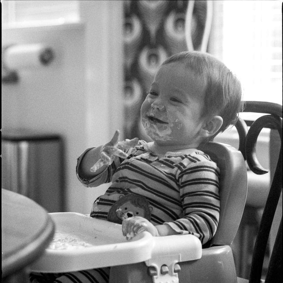 A small child smiling while eating